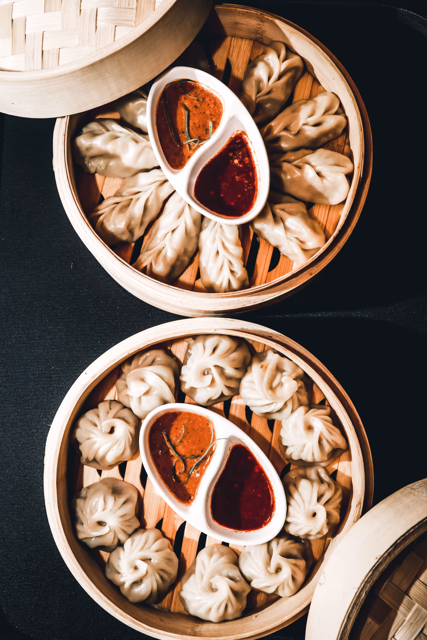 Steamed momos served with two styles of dipping sauce