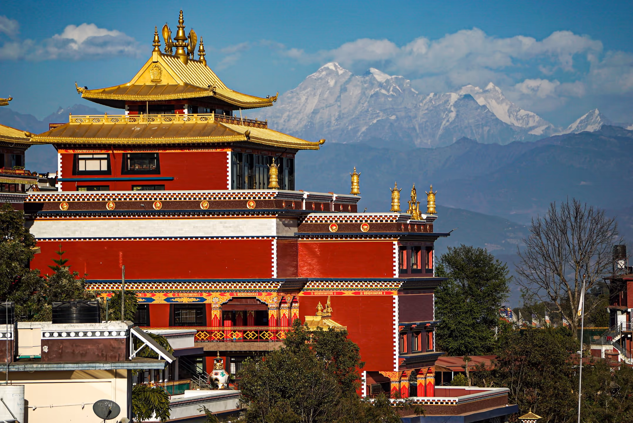 A Buddhist monastery (gompa) set against snow-capped Himalayan hills