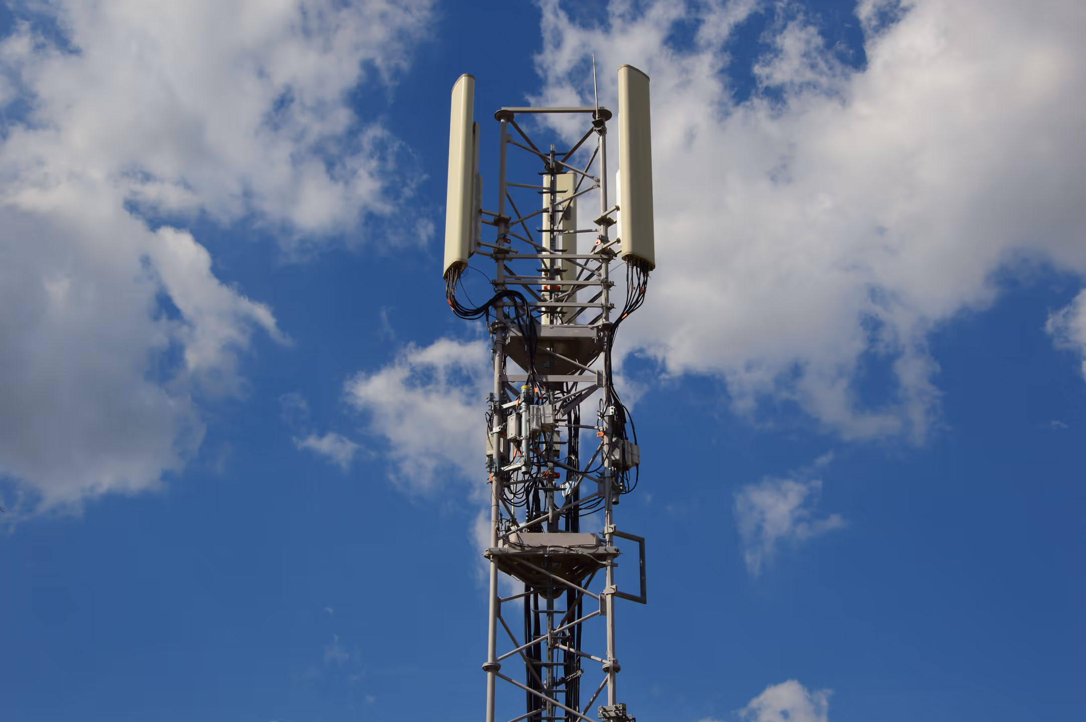 Internet tower with blue sky — the infrastructure that connects Nepal's remote monitoring network