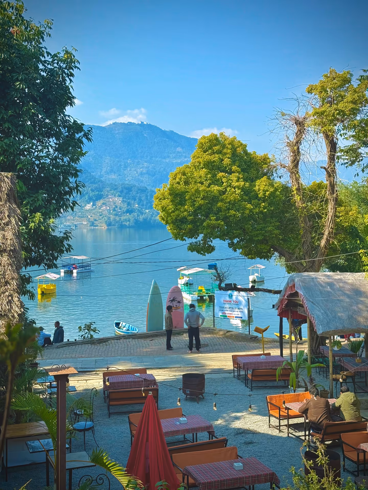 Boating on Phewa Lake in Pokhara with green hills reflected in the water