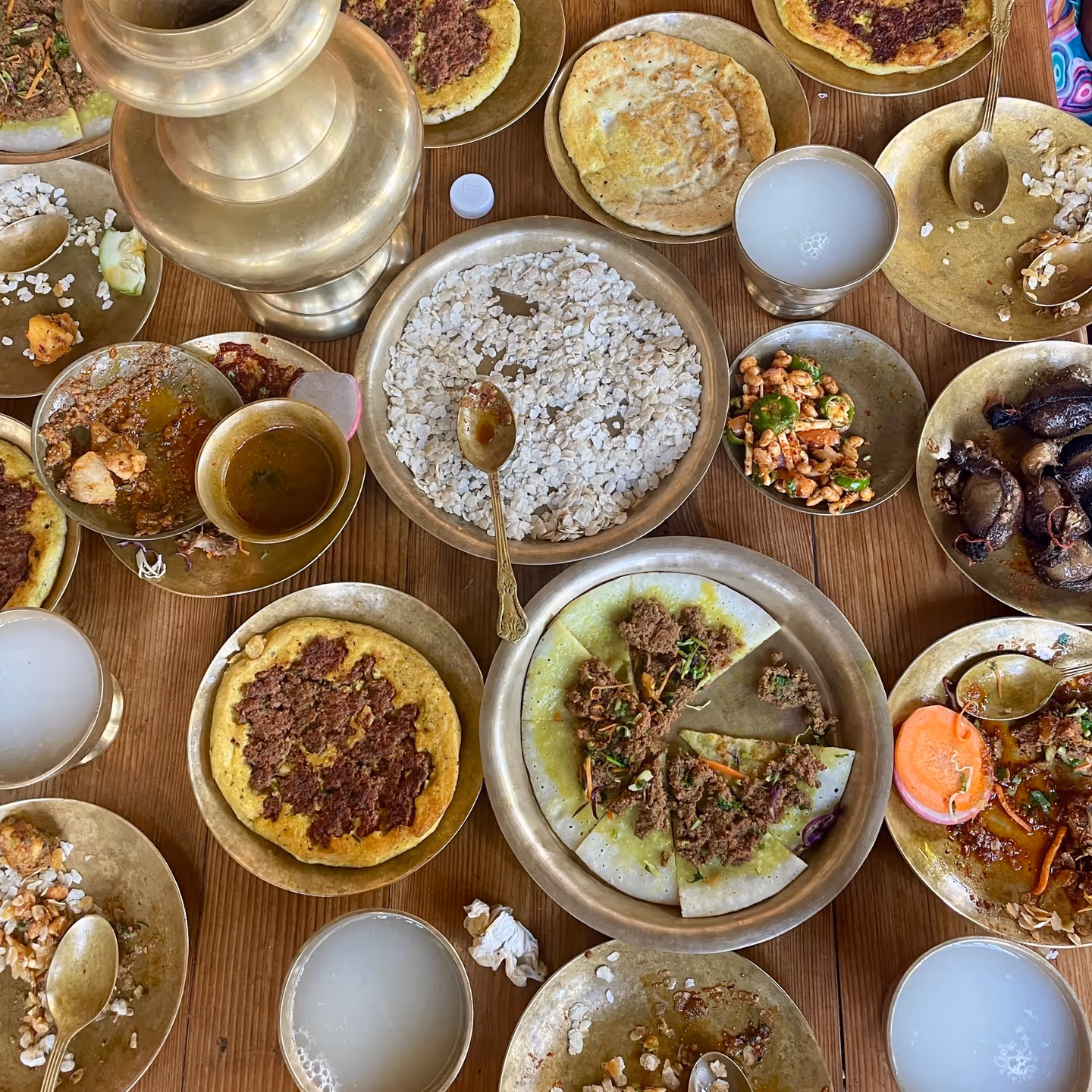 A traditional Newari feast spread across golden-coloured vessels