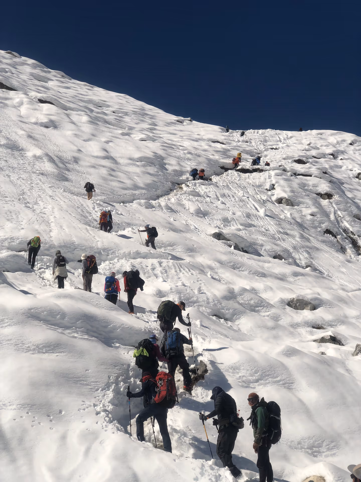 Trekkers walking through a snow-covered trail in winter Nepal