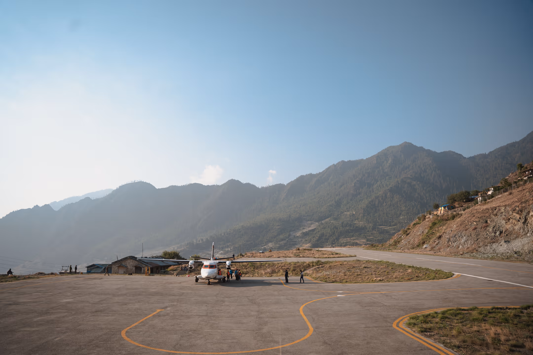 Domestic plane on a Nepal airport runway with hills in background